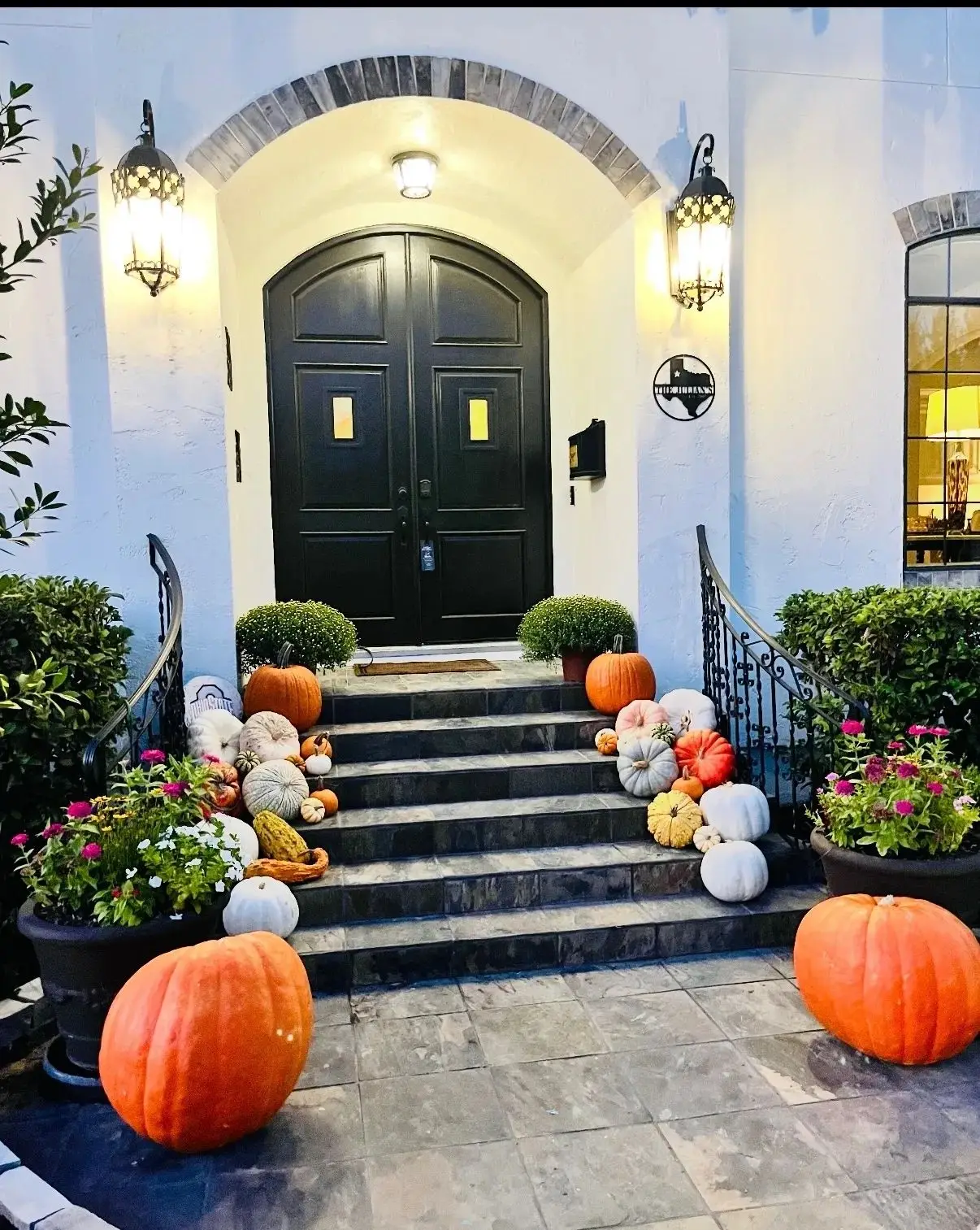 Seasonal porch display with mums and pumpkins